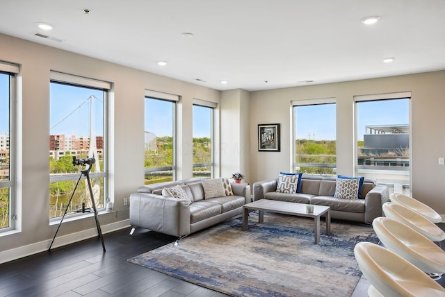 living area with dark wood-style flooring, baseboards, and recessed lighting