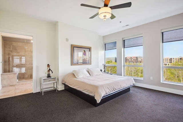 carpeted bedroom with multiple windows, baseboards, ensuite bathroom, and ceiling fan
