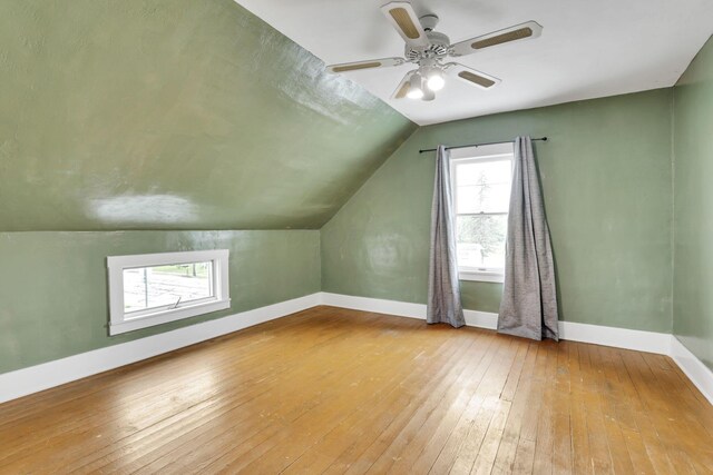 bonus room with wood-type flooring, baseboards, lofted ceiling, and a ceiling fan