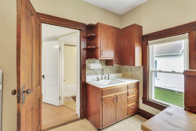 kitchen with a sink, light flooring, healthy amount of natural light, and light countertops