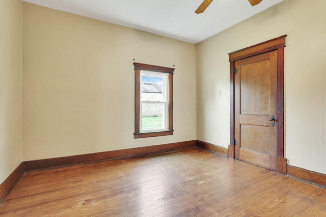 empty room with light wood finished floors, ceiling fan, and baseboards