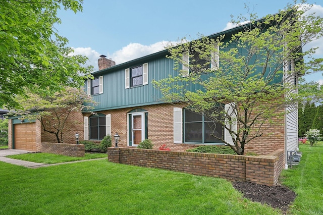 colonial inspired home with a chimney, a front yard, a garage, and brick siding