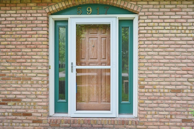 property entrance featuring brick siding