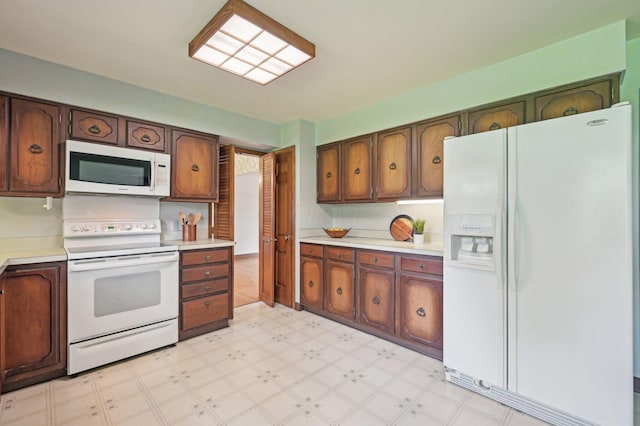 kitchen with white appliances, light floors, and light countertops