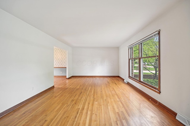 spare room featuring light wood finished floors and baseboards