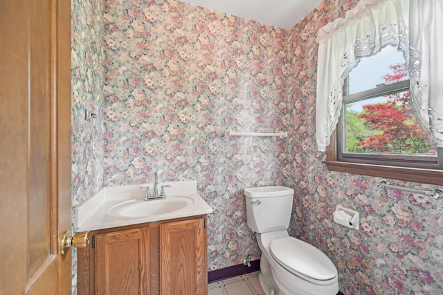 bathroom with wallpapered walls, vanity, toilet, and tile patterned floors