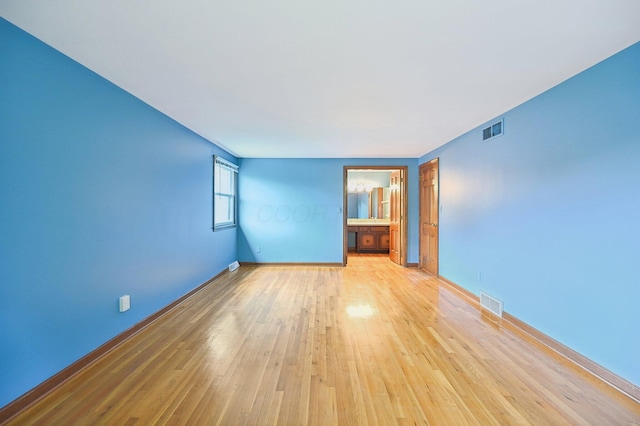 empty room featuring light wood-style flooring and baseboards