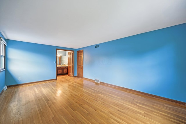 empty room featuring light wood-type flooring and baseboards