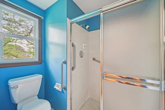bathroom with a shower stall and toilet