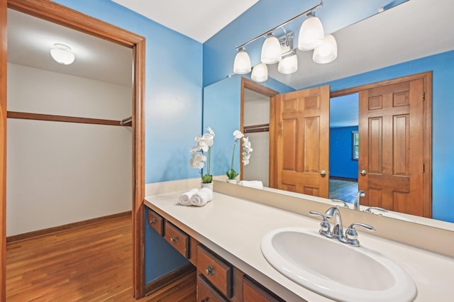 bathroom featuring wood finished floors, vanity, and baseboards