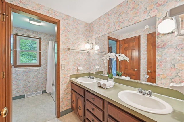 full bath with double vanity, baseboards, and shower / bath combo with shower curtain
