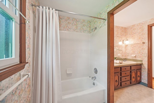 bathroom with wallpapered walls, shower / bath combo with shower curtain, and vanity