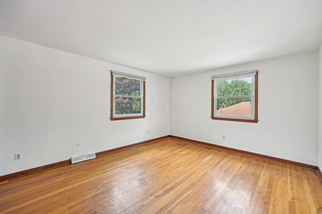 unfurnished room with light wood-style flooring and baseboards