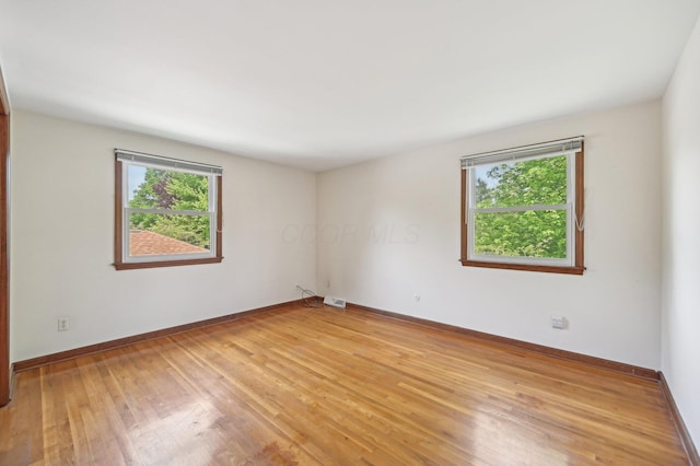 empty room featuring light wood finished floors and baseboards
