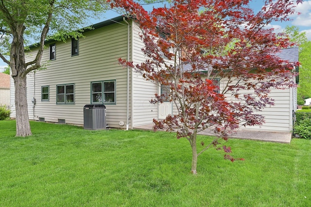 back of property featuring cooling unit and a lawn