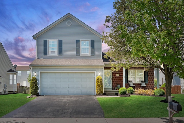traditional-style home featuring a front yard, a garage, fence, and driveway