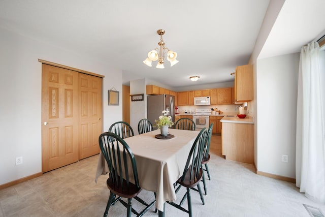 dining space featuring a chandelier, baseboards, and visible vents