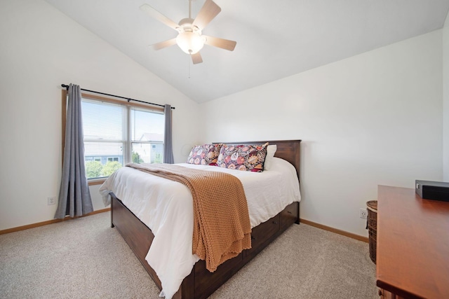 bedroom featuring light colored carpet, lofted ceiling, baseboards, and a ceiling fan