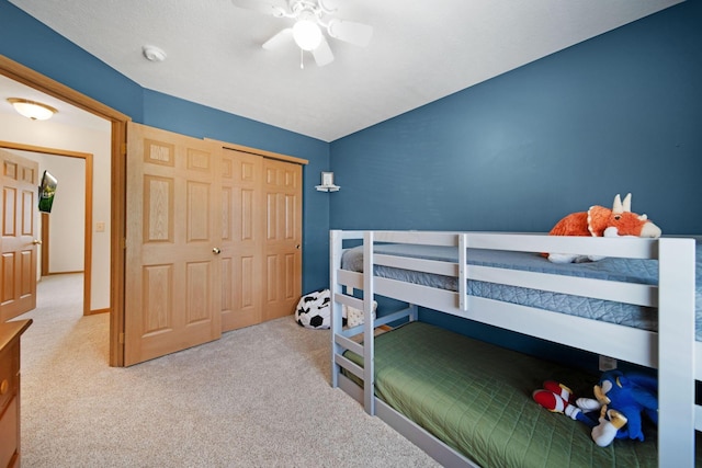 carpeted bedroom featuring a ceiling fan, lofted ceiling, and a closet