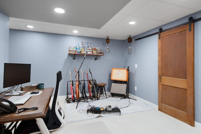 carpeted office with a drop ceiling, a barn door, baseboards, and recessed lighting