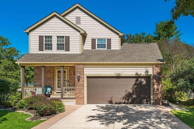 traditional home with a porch, roof with shingles, an attached garage, brick siding, and driveway