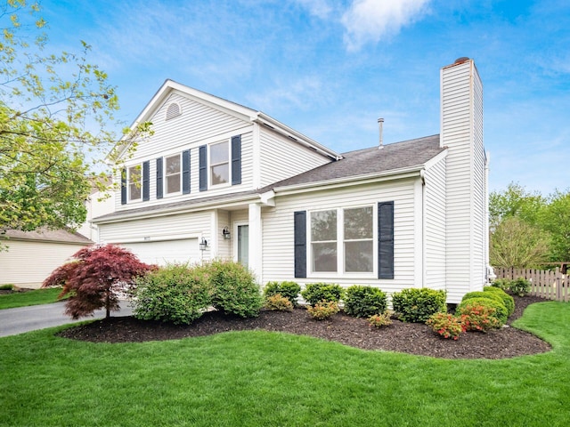 traditional-style house featuring a front lawn, fence, a chimney, and a garage