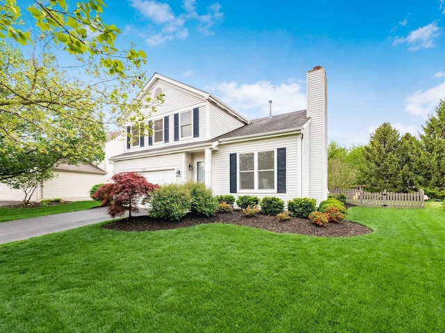 view of side of property featuring aphalt driveway, fence, an attached garage, a chimney, and a lawn