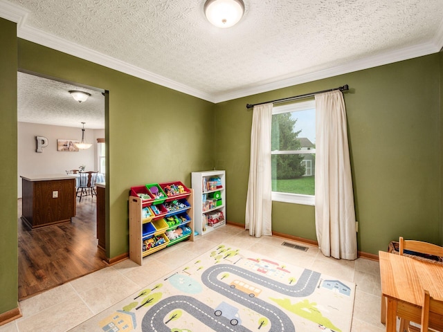 rec room featuring a textured ceiling, baseboards, visible vents, tile patterned floors, and crown molding