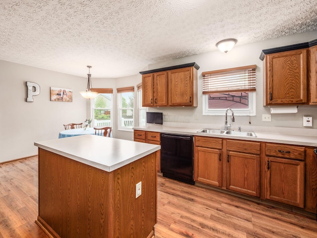 kitchen with light wood finished floors, a center island, brown cabinets, a sink, and dishwasher