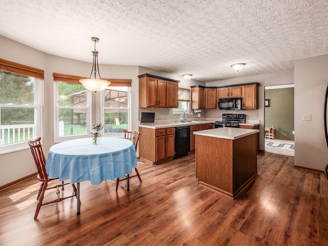 kitchen featuring brown cabinetry, black appliances, dark wood-style flooring, light countertops, and a kitchen island