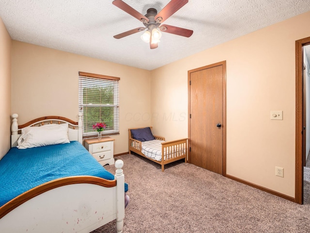 bedroom with a textured ceiling, carpet flooring, baseboards, and a ceiling fan
