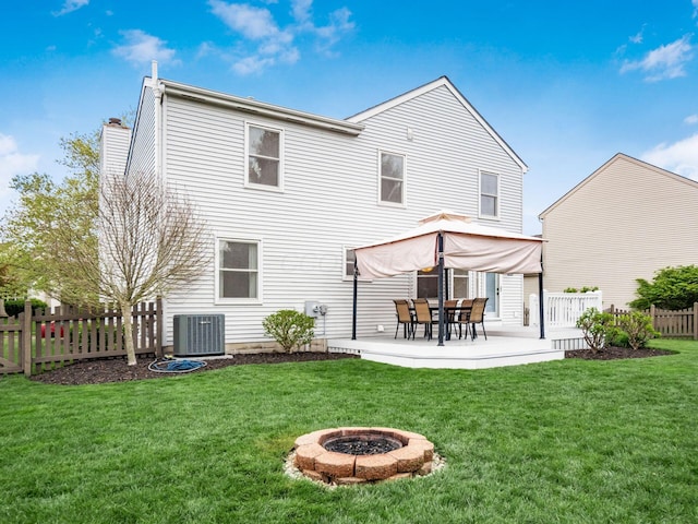 back of property with a chimney, a lawn, fence, a patio area, and central AC unit