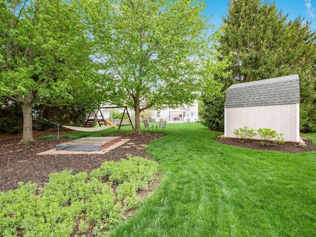 view of yard with an outdoor structure, a playground, and a shed