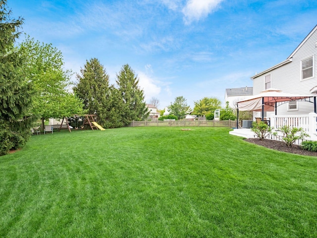 view of yard with a gazebo, central AC, a patio, a fenced backyard, and a playground