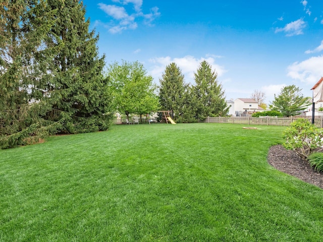 view of yard featuring a playground and fence