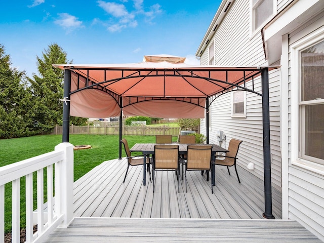wooden terrace with a yard, a gazebo, outdoor dining space, and a fenced backyard
