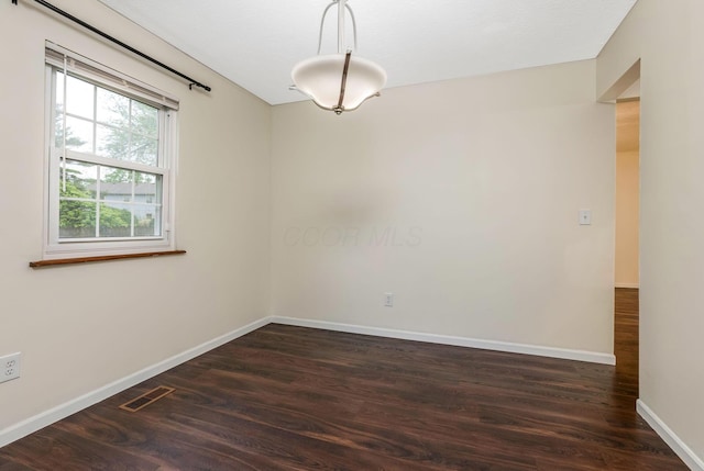 empty room featuring dark wood-style floors and baseboards