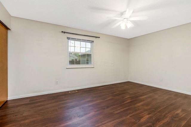 empty room with dark wood-style flooring, baseboards, and ceiling fan