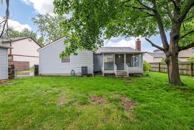 rear view of property featuring a sunroom and a chimney