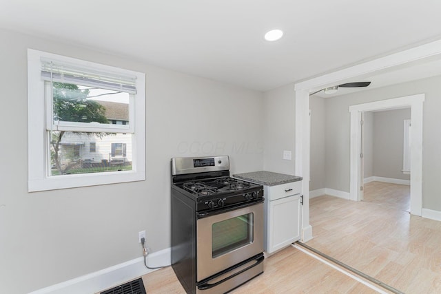 901 Campbell Ave, Columbus, OH 43223 - kitchen with stainless steel gas range, light wood-type flooring, baseboards, white cabinetry, and recessed lighting