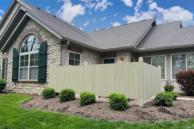 7742 Blue Juniper Dr, Westerville, OH 43082 - view of side of home with roof with shingles, fence, and stone siding