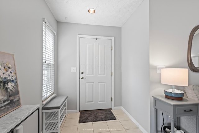 7742 Blue Juniper Dr, Westerville, OH 43082 - entryway with a textured ceiling, light tile patterned floors, and baseboards