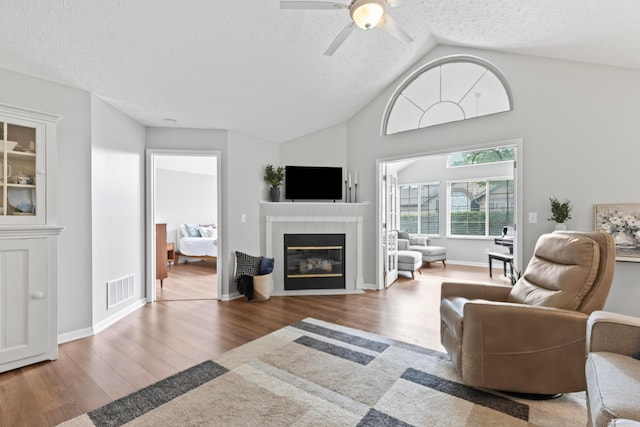 7742 Blue Juniper Dr, Westerville, OH 43082 - living room with a fireplace, wood finished floors, a textured ceiling, ceiling fan, and baseboards
