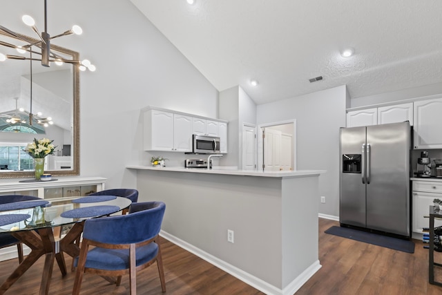 7742 Blue Juniper Dr, Westerville, OH 43082 - kitchen featuring appliances with stainless steel finishes, a chandelier, white cabinets, high vaulted ceiling, and dark wood finished floors