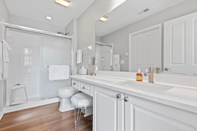 7742 Blue Juniper Dr, Westerville, OH 43082 - bathroom featuring a stall shower, wood finished floors, vanity, and toilet