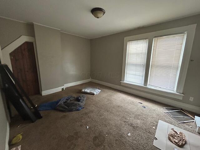 empty room featuring baseboards and carpet floors