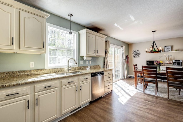 kitchen featuring a textured ceiling, pendant lighting, a sink, and dishwasher