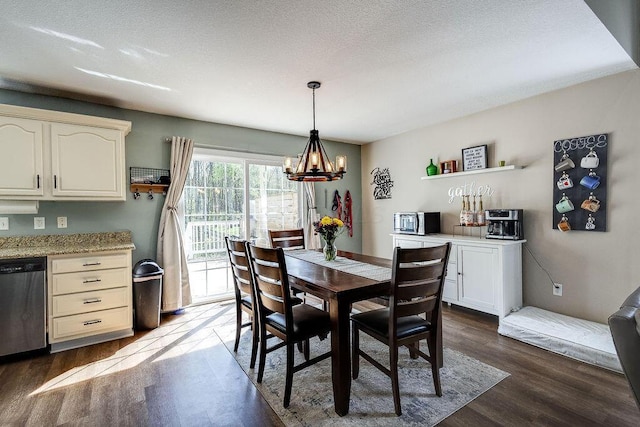 dining space featuring dark wood finished floors and an inviting chandelier