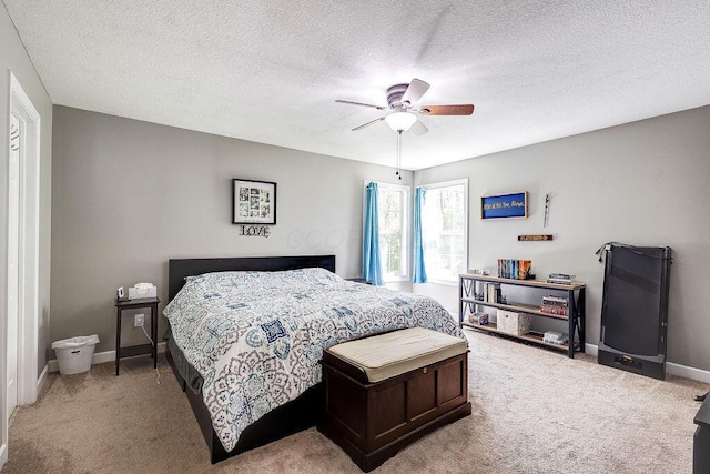 carpeted bedroom with baseboards, ceiling fan, and a textured ceiling