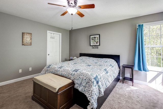 bedroom with carpet flooring, a textured ceiling, baseboards, and ceiling fan